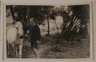 Raimund von Hofmannsthal neben einem Pferd stehend