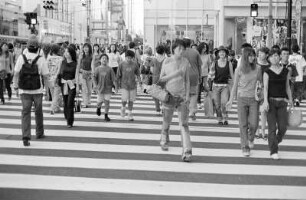 Straßenansicht mit Passanten, die über einen Zebrastreifen gehen, Tokio