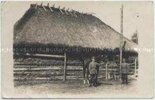 Deutschen Soldaten mit Pferd vor einem russischen Bauernhaus