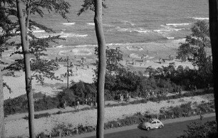 Timmendorfer Strand: Blick von oben auf den Strand, Vordergrund Bäume, unten Bäderstraße