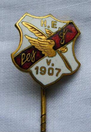 Vereinsabzeichen Stenographen-Verein Stolze-Schrey von 1907 Hamburg (mit langer Nadel) : Sammlung Beinhorn. Vereinsabzeichen Stenographen-Verein Stolze-Schrey von 1907 Hamburg (geflügelte Feder und Aufschrift "H. E. Stolze-Schrey v. 1907" auf weiß-rot-weißem Grund, mit langer Nadel). Email, Metall; Maße (ohne Nadel) 18 x 16,5 mm (um 1910). Dresden: SLUB R c 0295