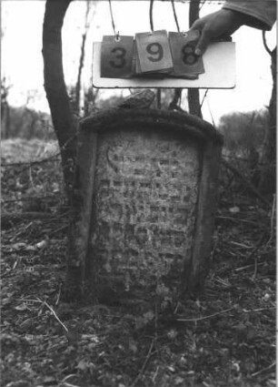 Grabstein 398 (Index: 99609122) Material: Sandstein Zustand: sehr stark verwittert Maße HxBxT: 49x36x13 cm Beschreibung: Stele, Segmentbogenabschluß, Schriftfeld eingetieft in gleicher Form: Grabstein 398