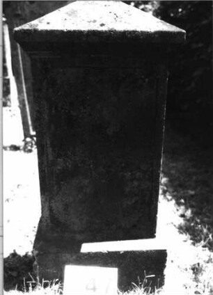 Grabstein 147 (Index: 100085455) Maße HxBxT: 95x43x25 cm Beschreibung: Stele, Sockel, Giebel, rechteckiges Schriftfeld eingetieft auf Vorderseite: Grabstein 147