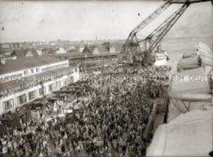 Menschenmenge in Bremerhaven verabschiedet den Hochseepassagierdampfer "Bremen" zur ersten Ausfahrt, "Jungfernfahrt"