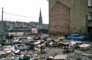Leipzig, März 1992. Sanierungsgebiet Lindenau. Schrott am Strassenrand, wilde Müllkippe, spielende Kinder