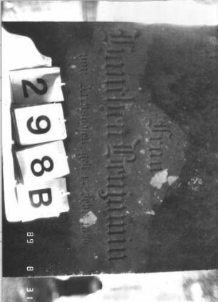 Grabstein 298 (Index: 99609935) Material: Sandstein Zustand: verwittert, angeschlagen Maße HxBxT: 213x69x27 cm Beschreibung: Stele, Giebel mit Verdachung, Seitenakrotere, Schriftfeld rechteckig eingetieft, von Halbpfeilern begrenzt, getreppter Sockel Symbolik: forale Seitenakrotere: Grabstein 298B