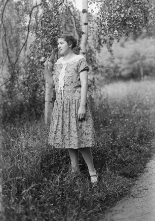 Portrait einer jungen Frau, vor Birken stehend