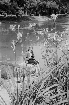 Ein lesendes Mädchen am Kanal