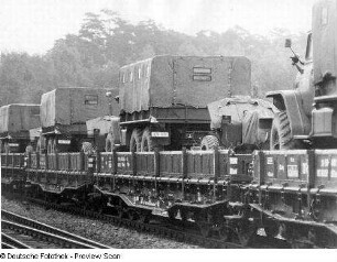 Deutschland . Truppenübungsplatz Klietz. Nationale Volksarmee - Landstreitkräfte. Truppenverlegung per Eisenbahnmarsch. Flachwagenzug mit Lastkraftwagen (wohl Typ Ural) und Geschützen