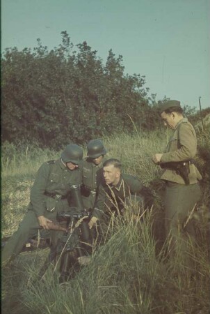 Zweiter Weltkrieg. Vier Wehrmachtsangehörige an einem Maschinengewehr (vermutlich während der Ausbildung)