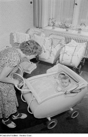 Mutter mit zwei Kindern im Kinderwagen in der Mütterberatung