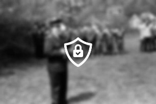 Kreisjugendheim Lütjensee: Zeltlager der Jugendfeuerwehren: Kreisjugendwart [Name maskiert] dahinter angetretene Jugendwehren: hinten Büsche, Bäume und Gebäude: 10. [Name maskiert]