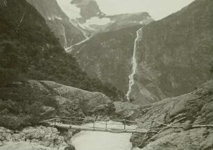 Norwegen. Brigsdalsgletscher (Briksdalsbreen, Nebenarm des Jostedalsbreen). Brücke über seinen Abfluß mit Blick auf den Vålefoss