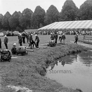 Hoisdorf: Amtsfeuerwehrfest: Turnierplatz des Hofes von Karl Düwiger: Aufbau der Wasserpumpen am Teich: im Hintergrund Löschfahrzeuge, Festzelt und Zuschauer: dahinter Baumreihe