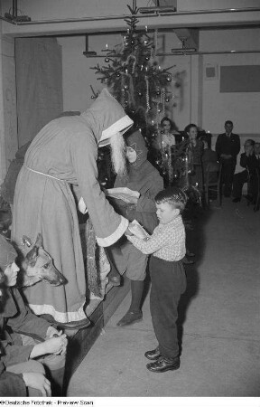 Weihnachtsmann, einem Jungen ein Geschenk überreichend
