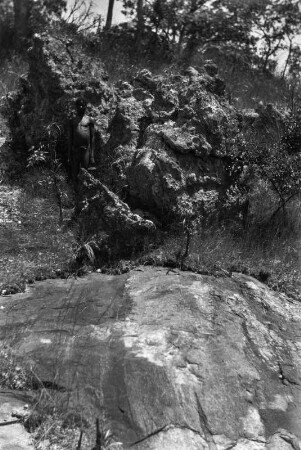 Schiefer und Gneis : Eine Schiefer- und Gneisscholle, vom Fluss glatt geschliffen. Darüber, neben dem Mann, ein stark verwitterter Granitfelsen.