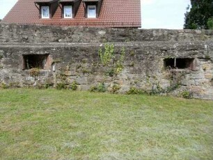 Kirchhof im Norden-Kirchhofmauer mit Schießscharten in Brusthöhe sowie Wehrgang-Steinbrüstung nicht mehr original hoch-hölzerner Laufgang fehlt