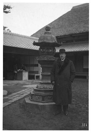 Nara, Japan. Tourist an steinerner Heiligen Laterne in einem Tempel stehend