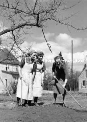 Arbeitsmaiden des Reichsarbeitsdienstes erhalten eine Einweisung in Gartenarbeit