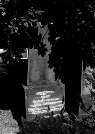 Grabstein 74 (Index: 100109949) Material: Sandstein Zustand: verwittert mit Textverlust Maße HxBxT: 200x72x34 cm Beschreibung: Obelisk, getreppter Sockel Steinmetz: Isenmann & Abele: Grabstein 74