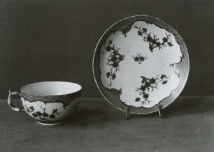 Tasse und Untertasse mit eisenroten indianischen Blumen