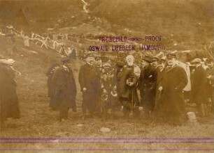 Bei Tromsø/ Norwegen: Im Samenlager. Gruppenbildnis Touristen mit einer Samin in einem Samenlager mit Rasensodenhütten bei Tromsø
