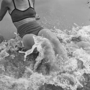 Frau im Bikini im Wasser der ankommenden Wellen am Strand von Henkenhagen (heute: Ustronie Morskie)