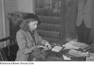 Portrait einer Frau am Tisch (mit neuem Geld?)
