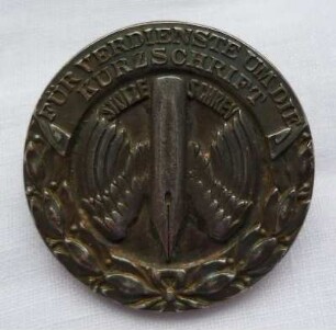 Verdienstabzeichen Stolze-Schrey (mit kurzer Nadel) : Sammlung Beinhorn. Verdienstabzeichen Stolze-Schrey (geflügelte Feder und Lorbeerkranz, mit kurzer Nadel). Metall; Durchmesser 27 mm. Dresden: SLUB R c 0172