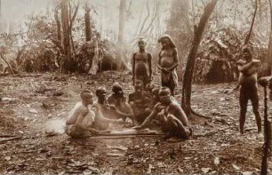 Gruppenportrait : Gruppenportrait mit mehreren Männern auf einem Platz vor ihren Hütten