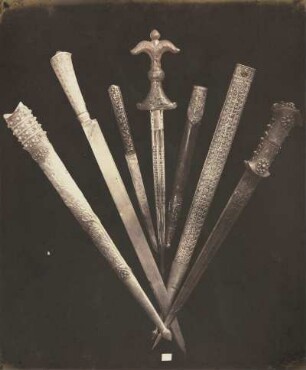 Sieben türkische und persische Dolche und Messer, mit geschnittenen und in Gold ausgelegten Griffen von Nephrit und niellierten Gold- und Silberbeschlägen, zwei Fünftel Naturgröße