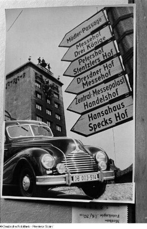 Vorderansicht eines fahrenden BMW 340, dahinter Wegweiser zu den Messehäusern, im Hintergrund das Kroch-Hochhaus (Fotomontage)