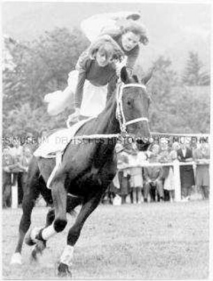 Zwei Frauen beim Turnen auf dem Pferd
