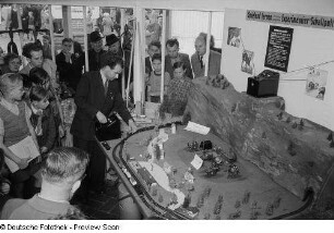 Besucher betrachten die Vorführung einer Modelleisenbahn auf der Leipziger Herbstmesse 1954