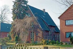 Struhbarg 18: giebelständiges Wohnhaus aus Backstein: Straßenfront mit Eingangstür, Treppen: Traufseite mit Seitentür, Zwerchgiebel mit Schleppdach, schräg versetzte Fenster, Rankgitter: Vorgarten