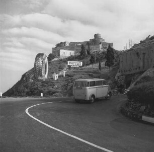 Sant’Alessio Siculo, normannisches Kastell am Capo Sant’Alessio mit Werbeaufsteller für einen Autoreifenhersteller und einem Kleinbus auf der Straße