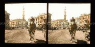 Bahnhofsplatz mit Kutschen, Kamelreiter, Gebäuden und Minarett in Kairo