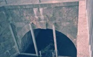 Mühlenredder: Brücke über Abfluss des Schlossgrabens in Aue: Seitenansicht von Süden: Teilansicht: Brückenbogen, davor senkrechte Eisenträger