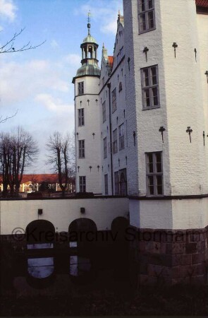 Schloss Ahrensburg: Ansicht von Nordwesten: Nordfassade mit angrenzenden Türmen: Brücke über inneren Schlossgraben zum Eingangsportal: im Hintergrund Marstall