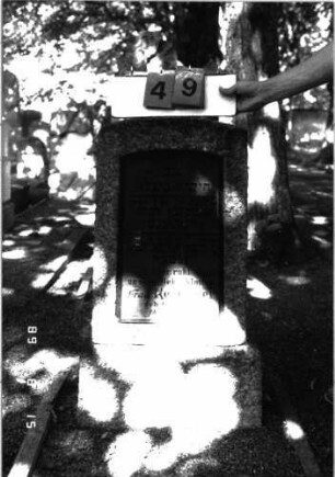Grabstein 49 (Index: 100105503) Material: Granit, schwarze Glasplatte Zustand: gut Maße HxBxT: 52x41x21 cm Beschreibung: konische Stele, Sockel, Segmentbogenabschluß, Schriftplatte: Grabstein 49