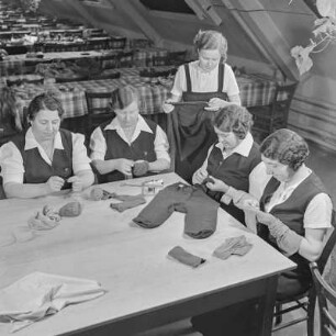 Werkfrauen beim Flicken von Kleidungsstücken