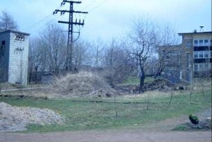 Ortsrand mit Trafostation, hinten Gebäude mit Sirene