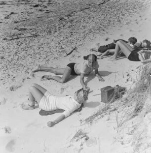 Elisabeth Gremmler und weitere Personen liegen am Strand