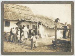 Gruppe einer ethnischen Minderheit (Roma) vor einem Wohnhaus in Abtsdorf : Abtsdorf (Cluj-Napoca-Manastor / Rumänien). Wohnhaus. Straßenansicht mit Angehörigen einer Roma-Gruppe