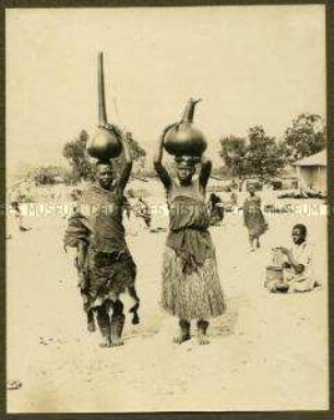 Afrikanische Träger mit traditionellen Krügen auf den Köpfen
