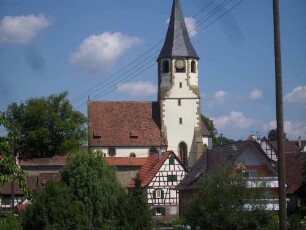 Ansicht von Süden mit Kirche (Chorturm mit Schlitzfenstern im Mittelgeschoß sowie achteckiger Glockenstube) über Kirchhofmauer mit Ortsumgebung