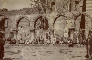 Hof der Ulu Cami : Der Innenhof der Ulu Cami (Große Moschee). Zahlreiche Männer sitzen an einem Zaun, rechts und links stehem Männer.