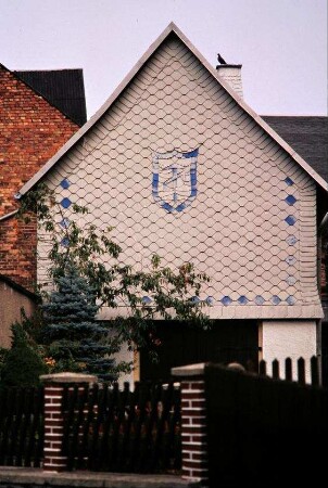 Haus des Dachdeckers im Ort, Innungszeichen am Giebel