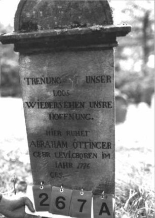 Grabstein 267 (Index: 100106921) Material: Sandstein Zustand: stark verwittert, teilweise Textverlust Maße HxBxT: 118x44x27 cm Beschreibung: Stele mit Abdeckplatte und Rundbogenaufsatz Besonderheit: vermutlich ein erneuerter Stein: Grabstein 267A