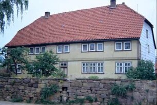 Pfarrhaus, davor Natursteinmauer